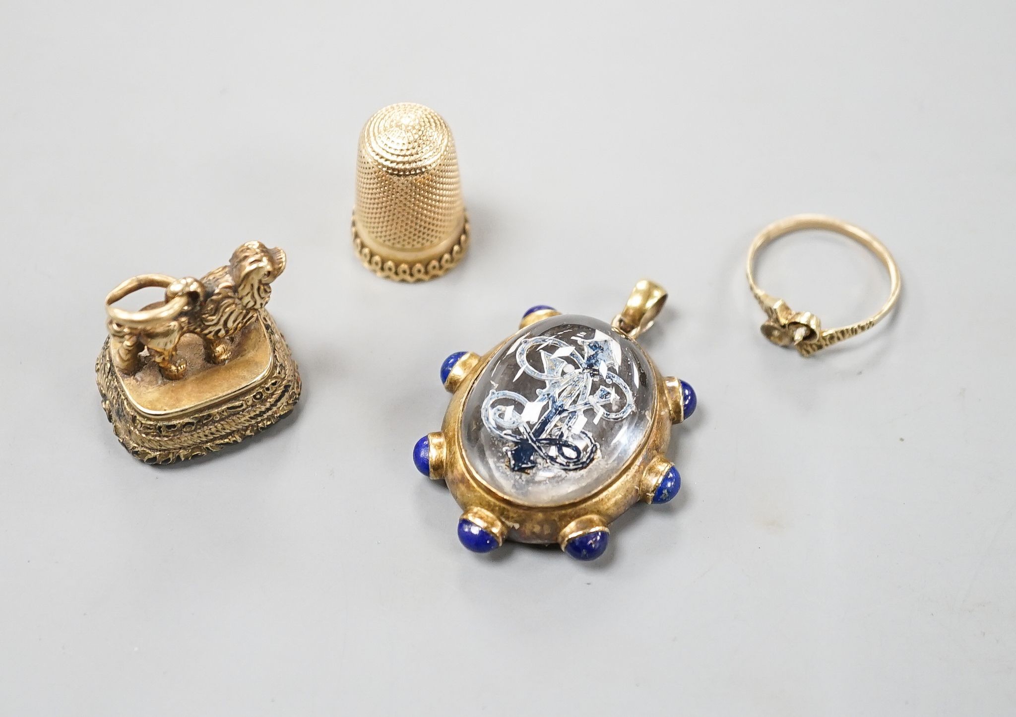 A yellow metal thimble, a 19th century yellow metal overlaid and carnelian set fob seal with poodle surmount, pendant and 9ct gold shank.
